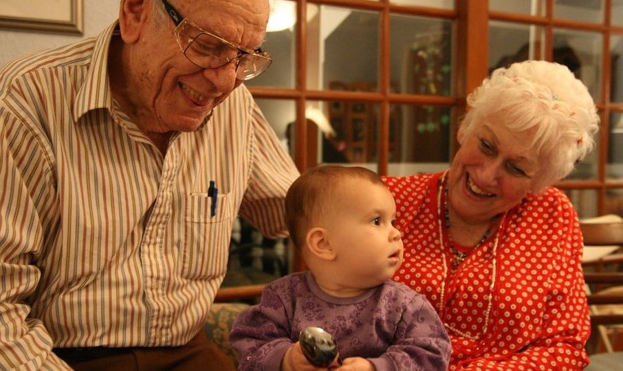 Grandparents smiling at toddler