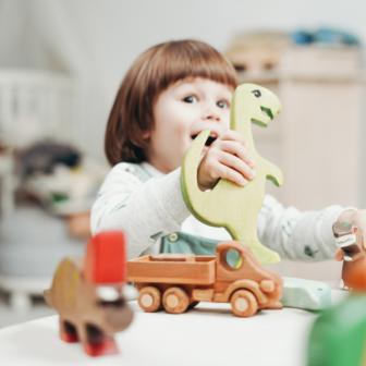 child with dinosaur toy